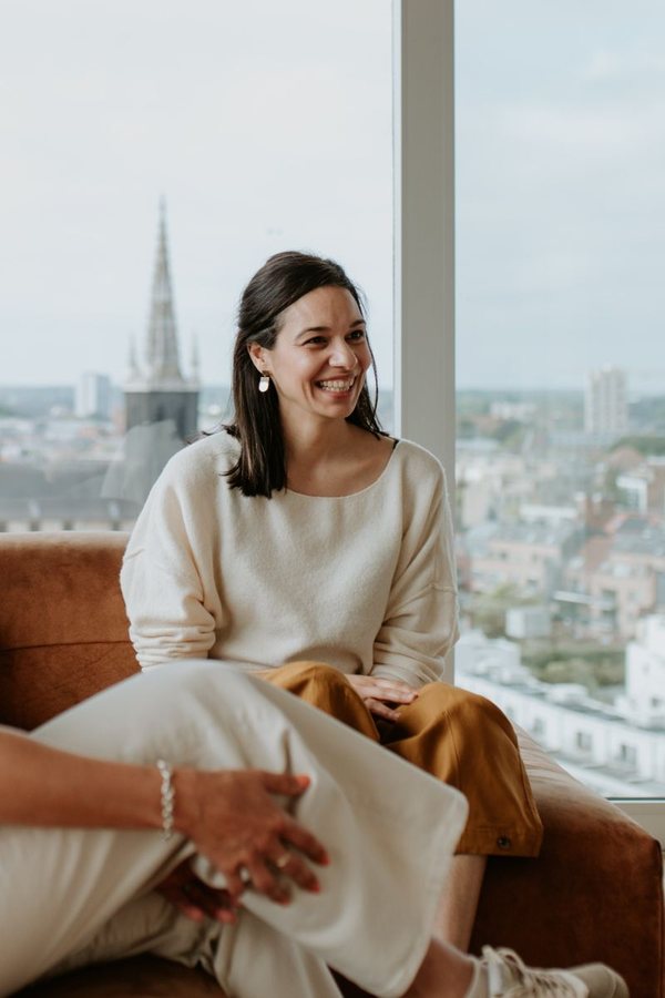 Klant van Florette Vervloet: onderneemster in een zetel voor een raam met uitzicht over de stad